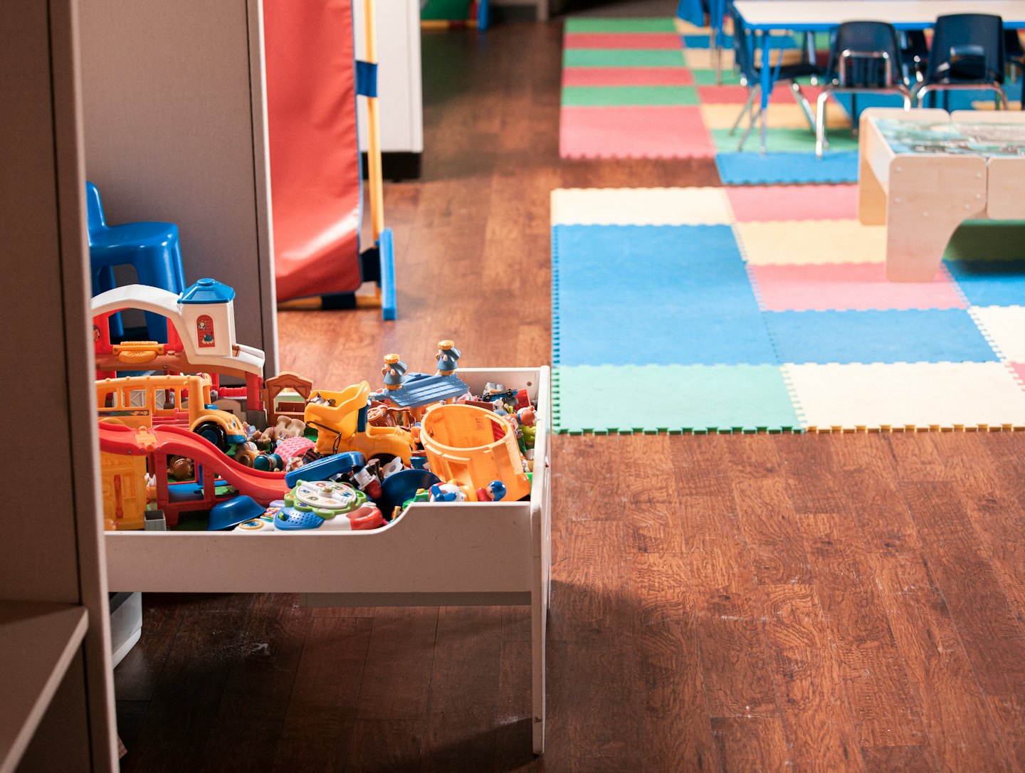 Contenitore di giocattoli traboccante di giocattoli colorati per bambini in una sala giochi.