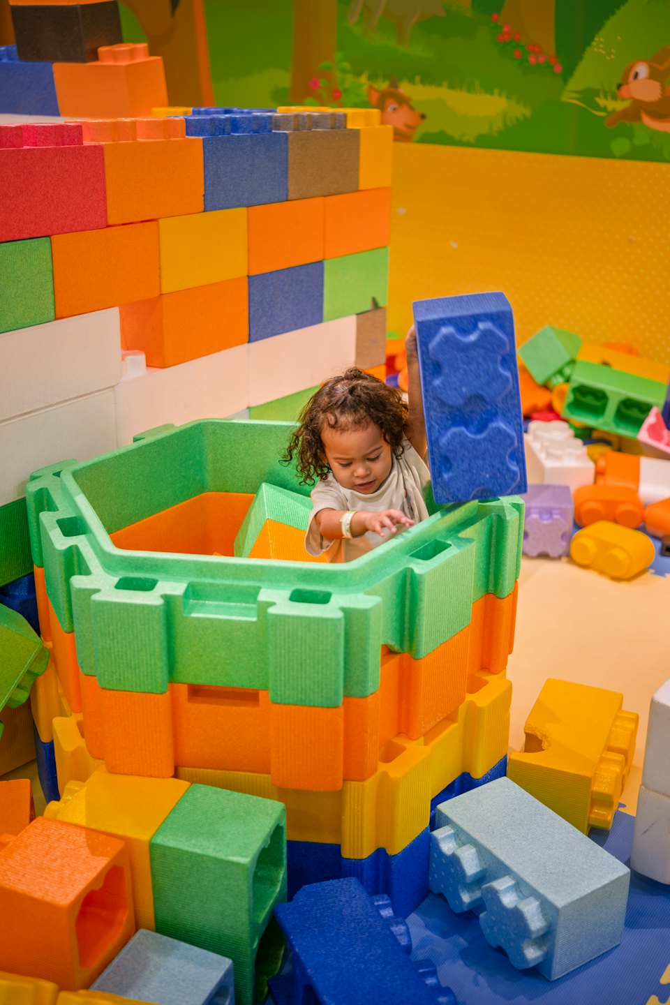Bambino gioca con blocchi colorati in una stanza dei giochi.